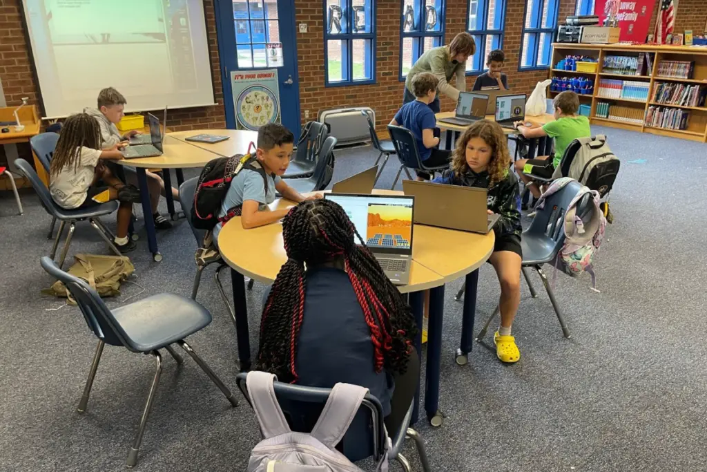A class of young students using computers.