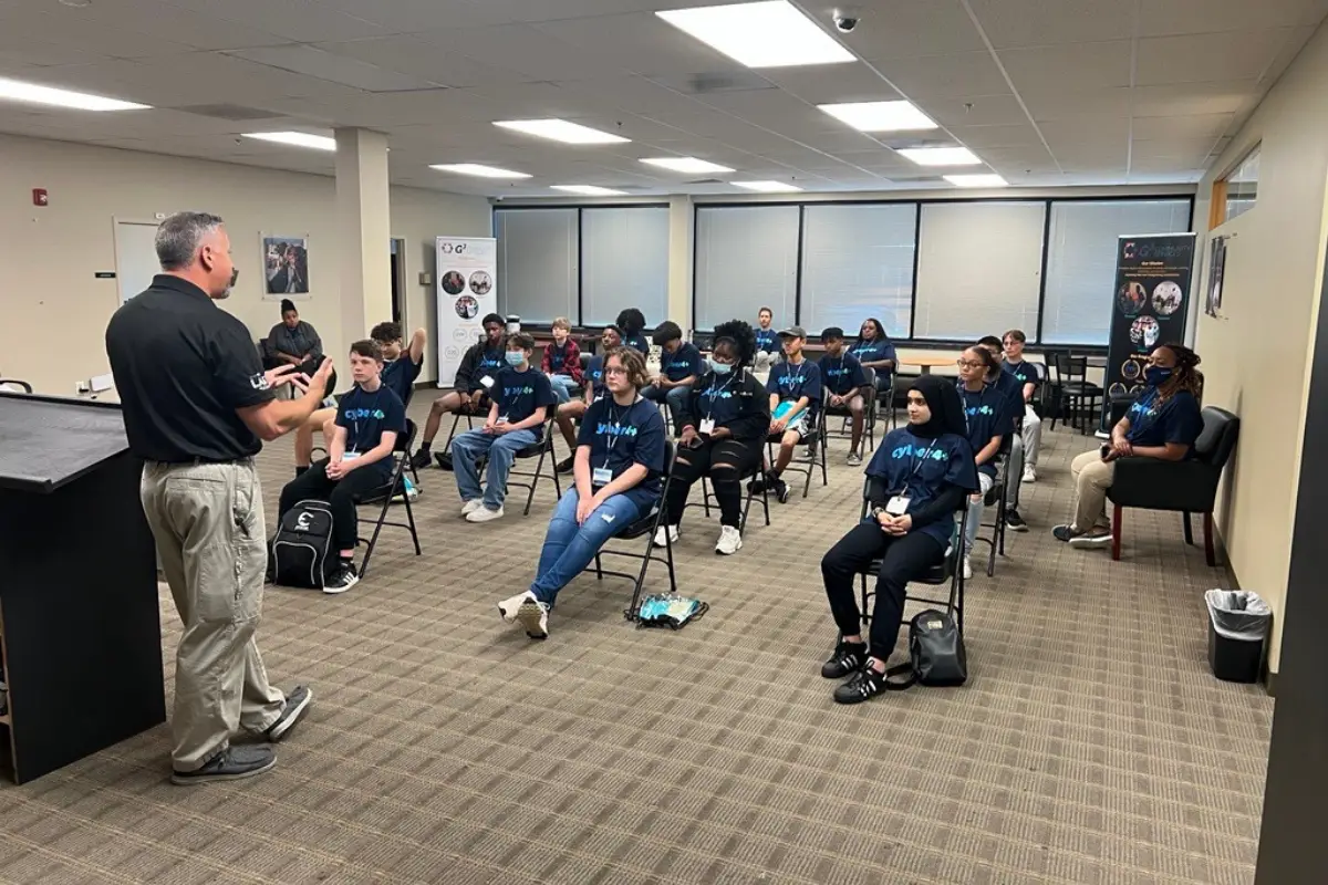 A group of students sitting in a classroom listening to a male speaker.