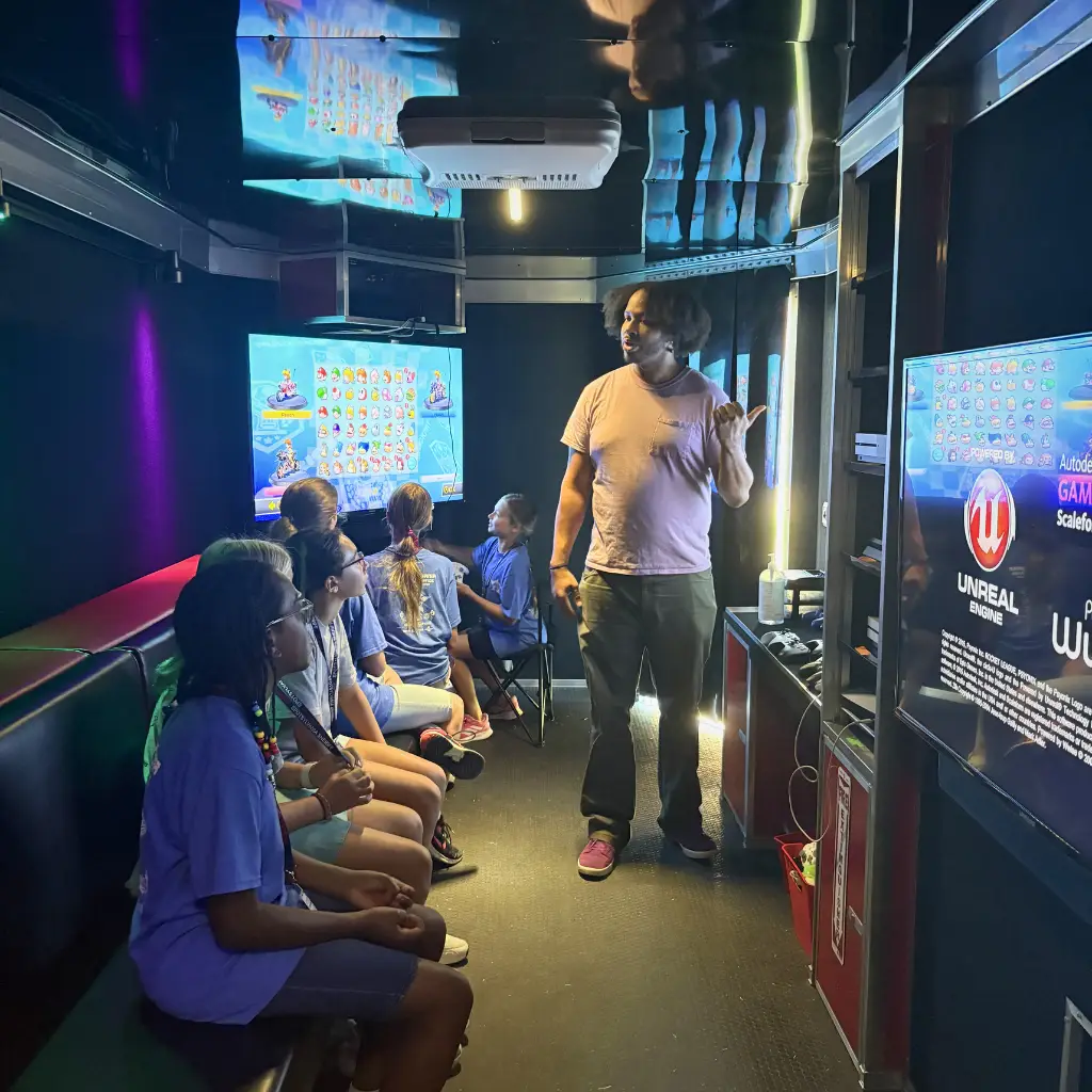 A STEM & Gaming Truck team member showing children the available video games.